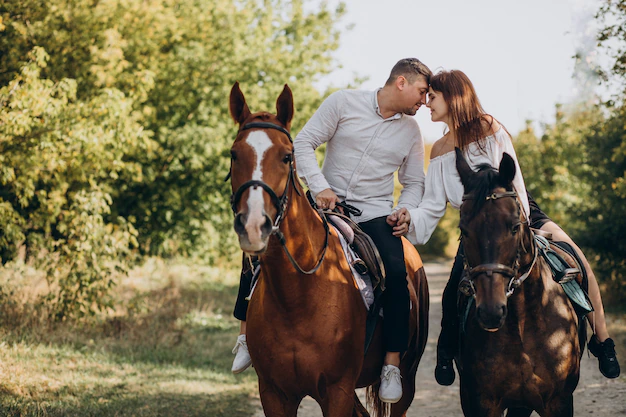 jeune-couple-equitation-chevaux-ensemble-dans-parc_1303-24491